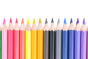 Lots of colored pencils lined upisolated on white background.
