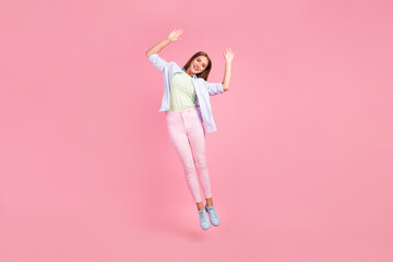 Full body photo of gorgeous glad person jumping raise opened hands palms isolated on pink color background