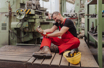 Worker suffering from pain after accident in factory. First aid support on workplace concept.