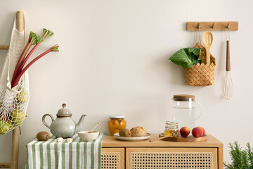Interior design of kitchen space with rattan commode,  ladder, rhubarb, vegetables, food and...