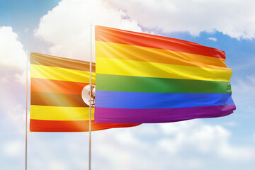 Sunny blue sky and flags of lgbt and uganda
