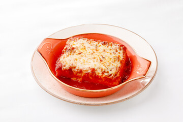 Lasagna with tomato sauce on a white background