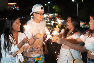 Latino friends with sparklers during the outdoor party