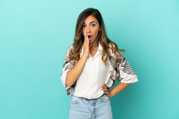 Young woman over isolated blue background surprised and shocked while looking right