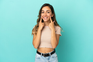 Young woman over isolated blue background smiling with a happy and pleasant expression