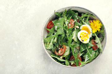Fresh dandelion salad on light background.