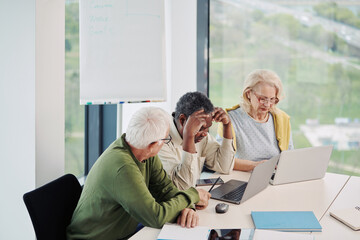 Obraz premium A small group of multicultural senior students sit in the classroom and working on school project.