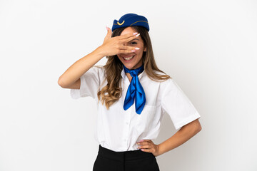 Airplane stewardess over isolated white background covering eyes by hands and smiling