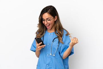 Young surgeon doctor woman over isolated white wall surprised and sending a message