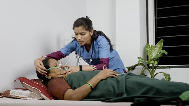 Wide Shot Of Nurse Wearing Oxygen Mask To Sick Senior Patient On Bed At Nursing Home - Concept Of Caretaker, Respiratory Illness Treatment And Medicare.