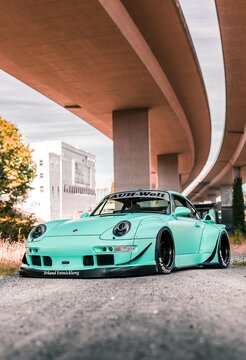 Tacoma, WA, USA
November 2, 2021
RWB Porsche 911 parked showing the front of the car and the drivers side of the car. A concrete overpass is overhead