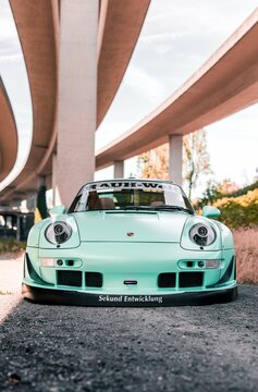 Tacoma, WA, USA
November 2, 2021
RWB Porsche 911 parked showing the front of the car and the drivers side of the car. A concrete overpass is overhead