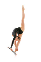 Studio shot of young flexible woman, rhythmic gymnastics artist performing with clubs isolated on white background. Concept of sport, action, aspiration