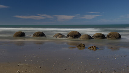 Landmark on the east coast of the South Island, Moeraki Boulders under a dramatic dawn sky.