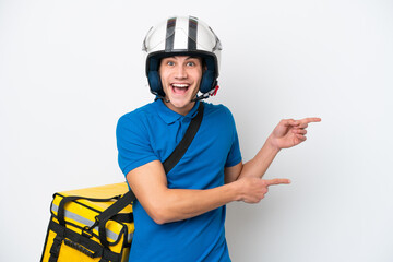Young caucasian man with thermal backpack isolated on white background surprised and pointing side
