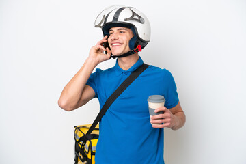 Young caucasian man with thermal backpack isolated on white background holding coffee to take away and a mobile