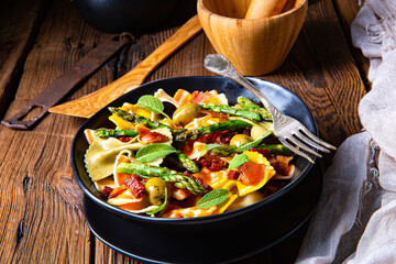Pasta salad with green asparagus, olives and parma ham