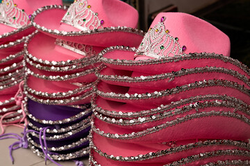 Stacks of pink princess stetson hats for sale at a carnival. © Inge