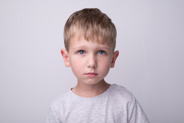 A boy with blond hair and a sad expression