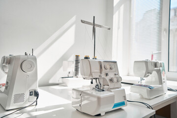 Modern sewing machines on table in factory