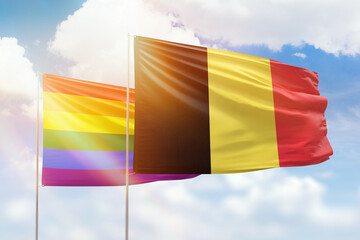 Sunny blue sky and flags of lgbt and belgium
