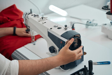Dressmaker working with red cloth and equipment