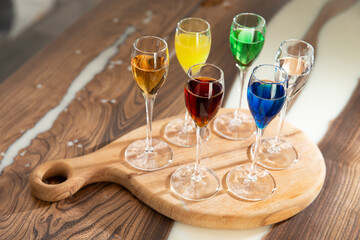 Various colored cocktails in shot glasses.