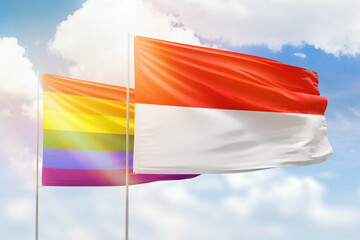 Sunny blue sky and flags of lgbt and indonesia