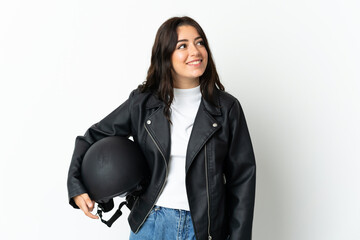 Woman holding a motorcycle helmet isolated on white background thinking an idea while looking up