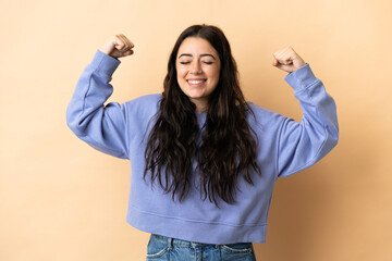 Young caucasian woman over isolated background doing strong gesture