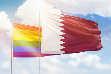 Sunny blue sky and flags of lgbt and qatar