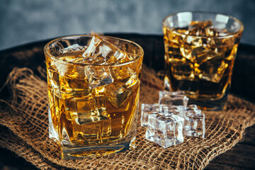 Glasses of whiskey with ice in a rustic setting