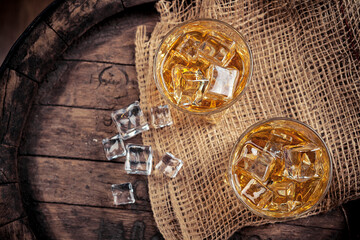 Glasses of whiskey with ice in a rustic setting