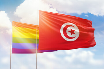 Sunny blue sky and flags of lgbt and tunisia