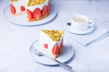 Freesier cake with fresh strawberries and pistachios. French classic dessert. Portion of cake on a white plate close-up.