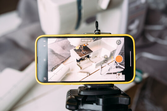 Shooting video of the sewing process, workshop on clothing design on smartphone - Powered by Adobe