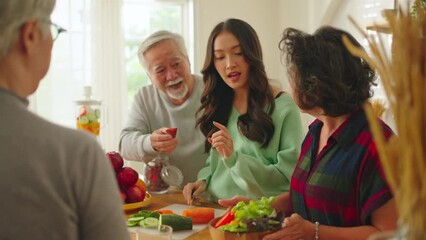 Group of Asian elder people friends making vegetables salad and fruit juice with her daughter in kitchen at home.concept of Group asia senior people Healthy eating,colorful fruits and vegetables. - Powered by Adobe