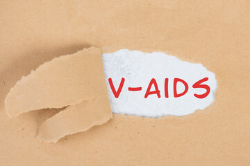 The words v-aids is standing in german language on on torn paper, vaccine damage, new autoimmune disease caused by covid-19 syringe, immune system injury, health issue
