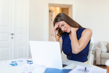 Exhausted businesswoman having a headache in home office. creative woman working at office desk feeling tired.