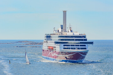 ships in the Baltic sea. Big ferry and a small sailboat. Blue water of the Stockholm fiord, blue sky with clouds