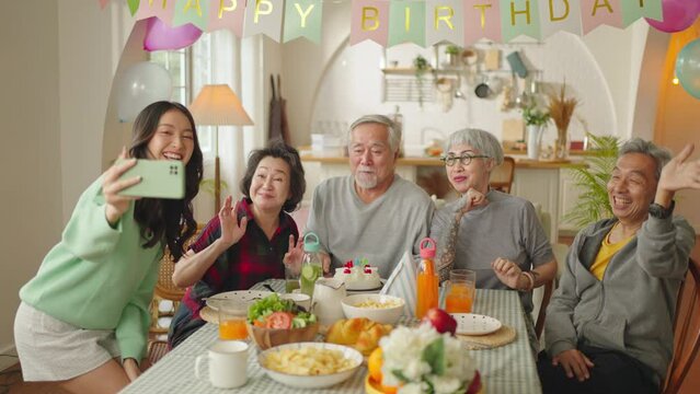 celebrating birthday at retirement at home.Group of Asian elderly people having birthday party at daycare.group asian senior people laugh smile positive conversation greeting in birthday friend party.