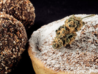 Vegan sugar-free cocoa truffles and medical cannabis bud on a slate plate.