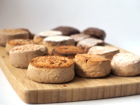 Spanish Polvorones y Mantecados are traditional Christmas sweets. Lots of cakes on a wooden board.