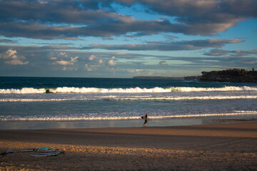 Fototapeta na wymiar an Australian surfer is walking on the Bondi Beach, Sydney with his surfboard