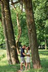 full length of happy young couple in summer standing near lake, embracing, happy people in park...