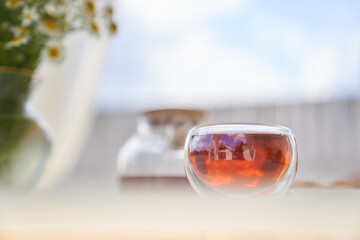 Transparent glass Cup of tea in nature. The concept of breakfast in the backyard of the house....