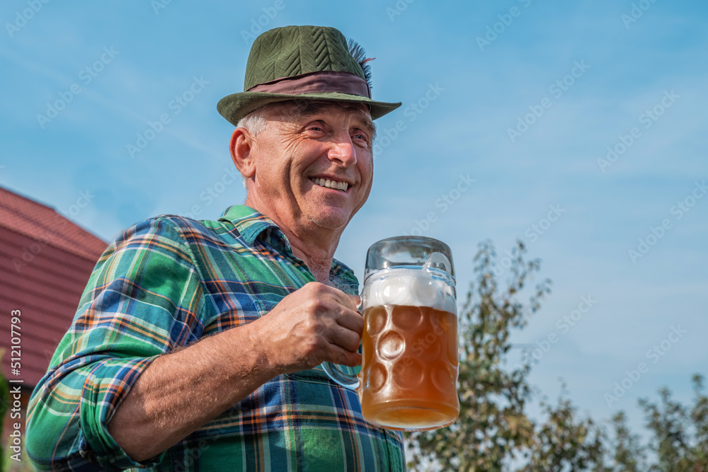 Wall mural Senior men with beer mugs with Bavarian beer in Tyrolean hats celebrating a beer festival in Germany. Happy old people during the October holiday in Munich