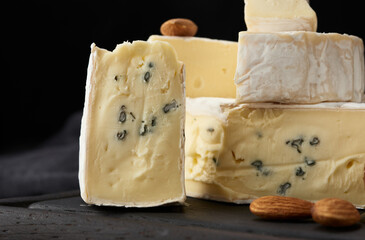 brie and bergader blue cheese on a brown wooden board, delicious snack