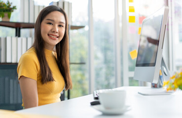 Portrait happy young programmer Asian woman work at start up technology office and using computer for coding application program and fully creative. Concept of smart entrepreneur woman working.