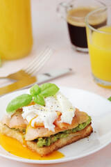 Breakfast with a sandwich with poached egg and avocado	